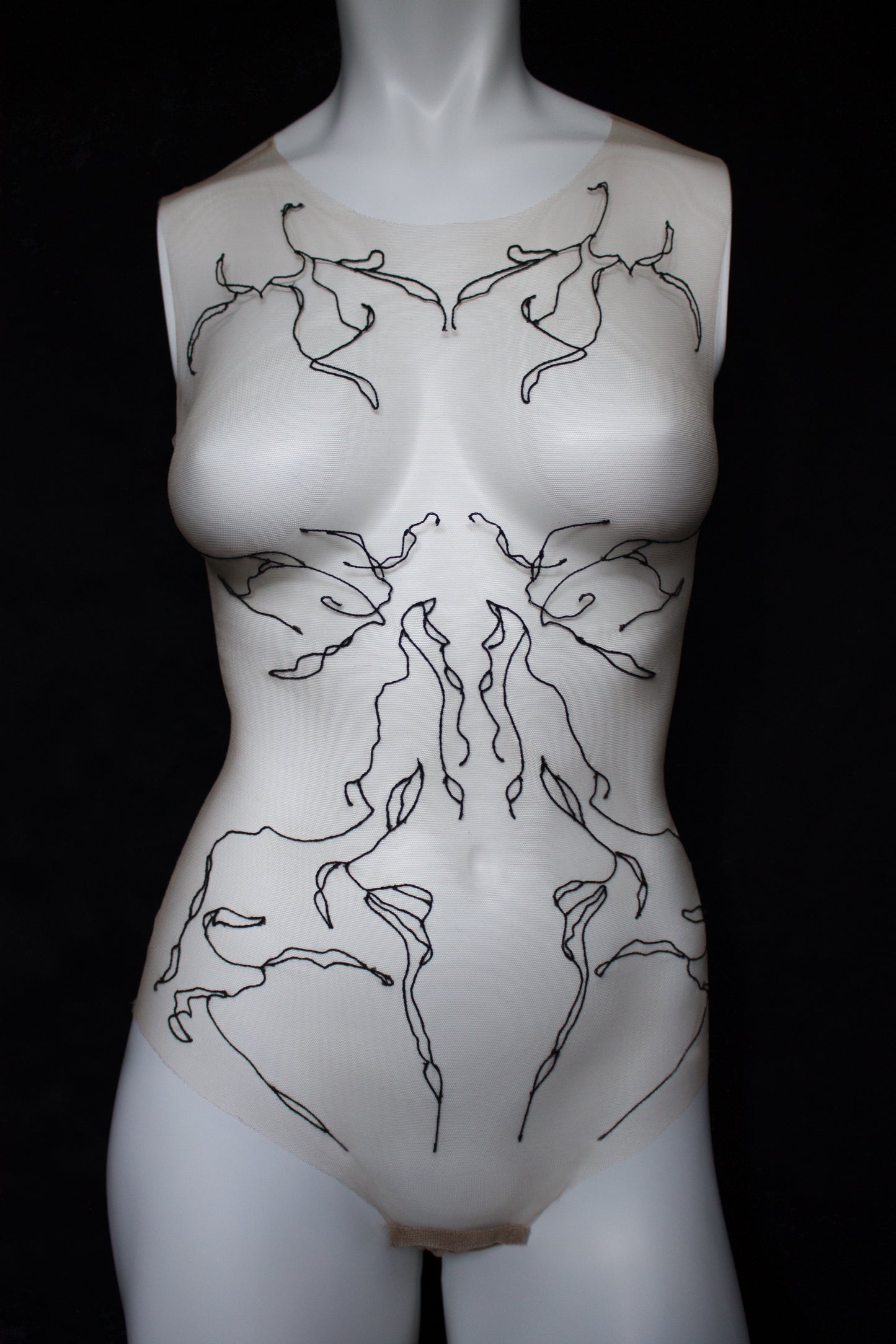 Mannequin torso with black line art design on a black background