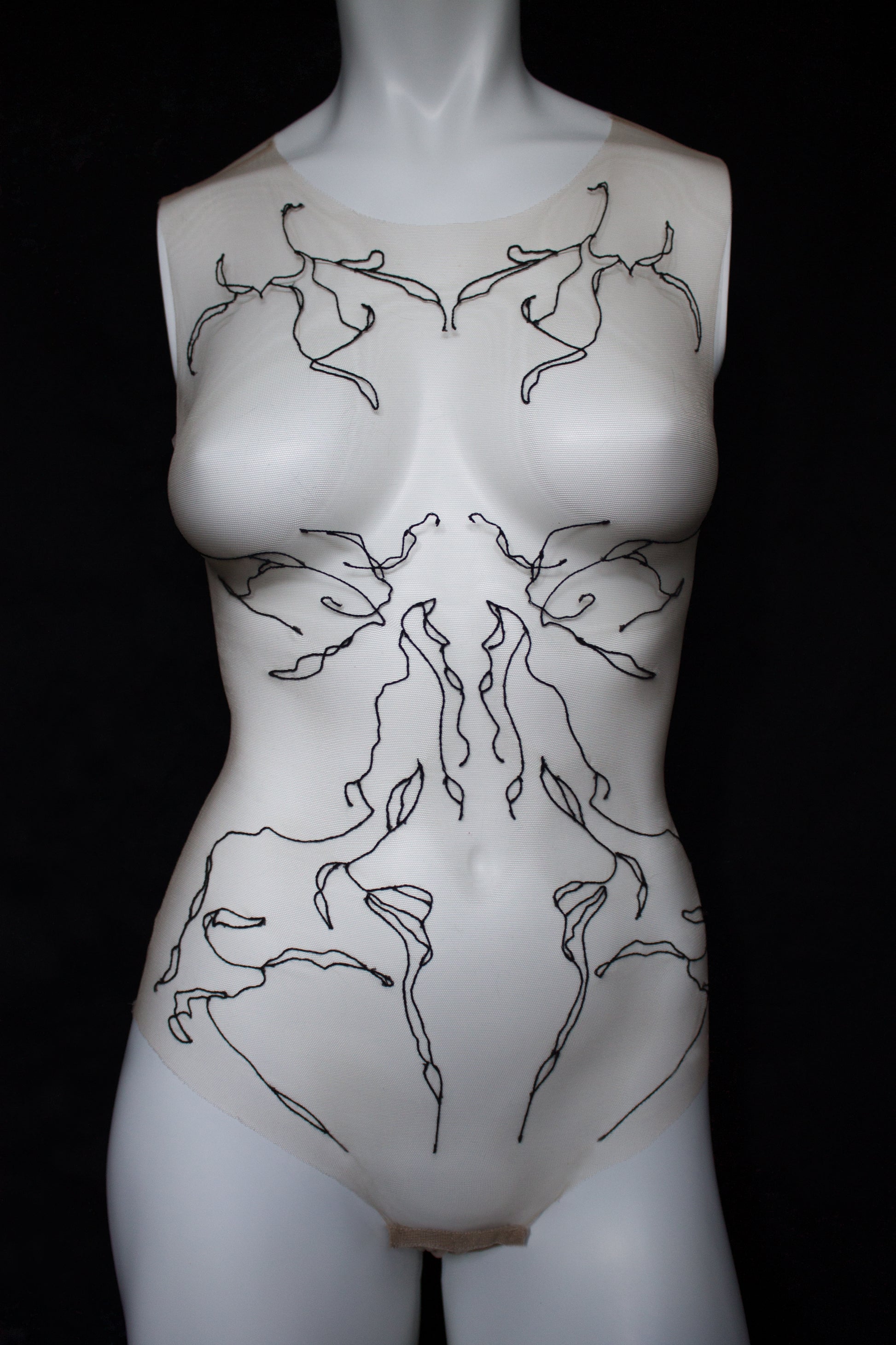 Mannequin torso with black line art design on a black background