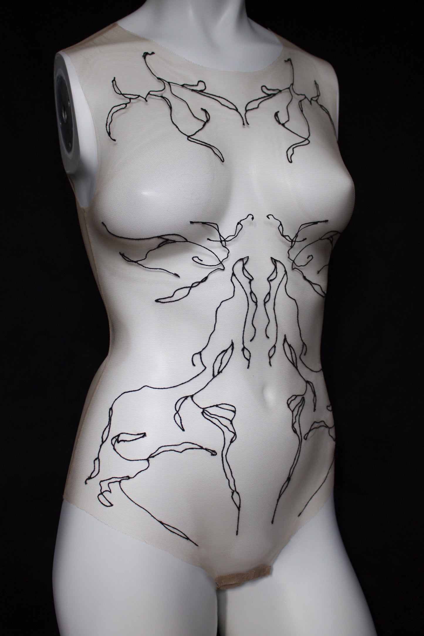 Mannequin torso with black abstract designs on a black background