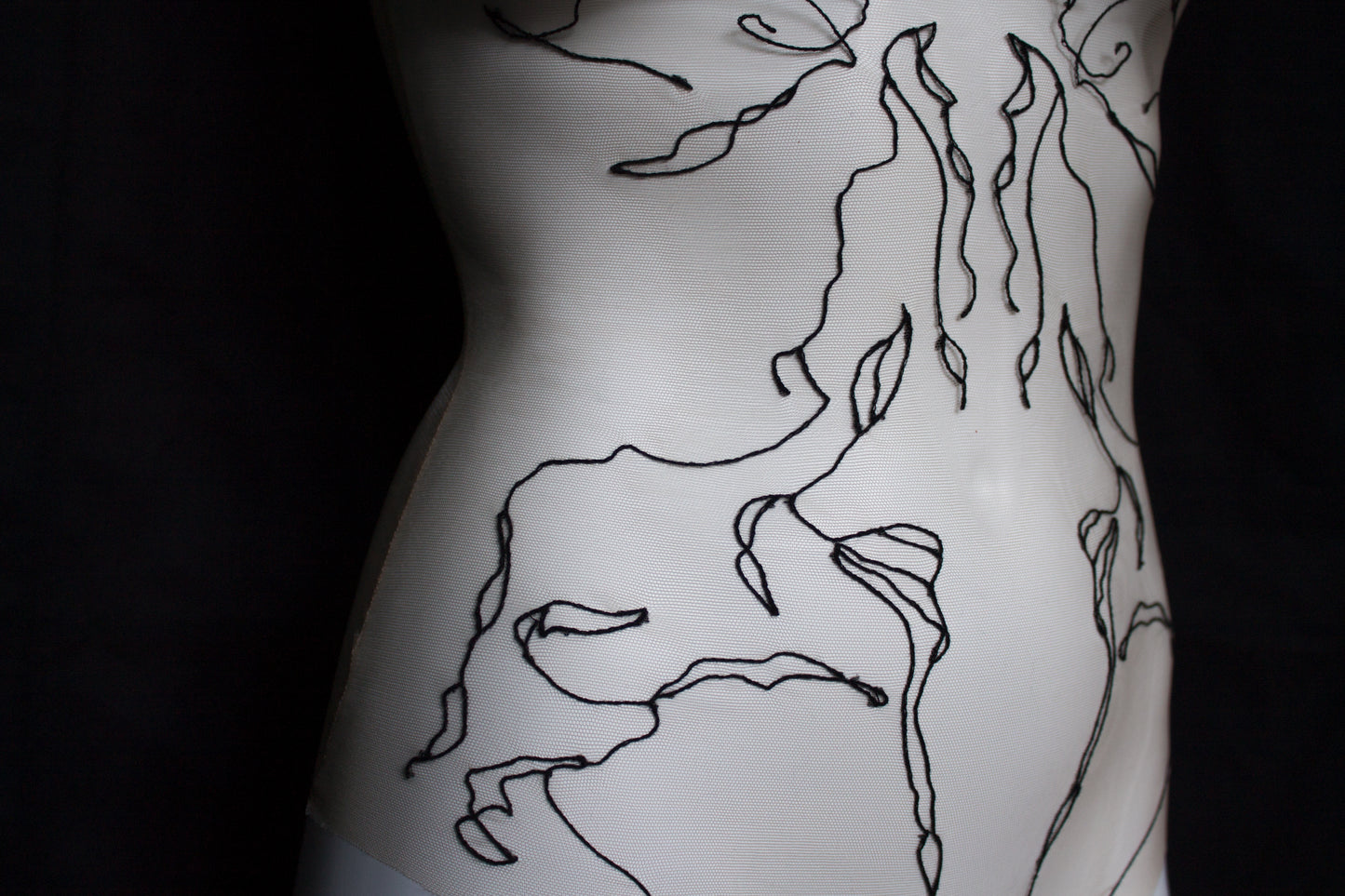 Black abstract designs on a mannequin with black background