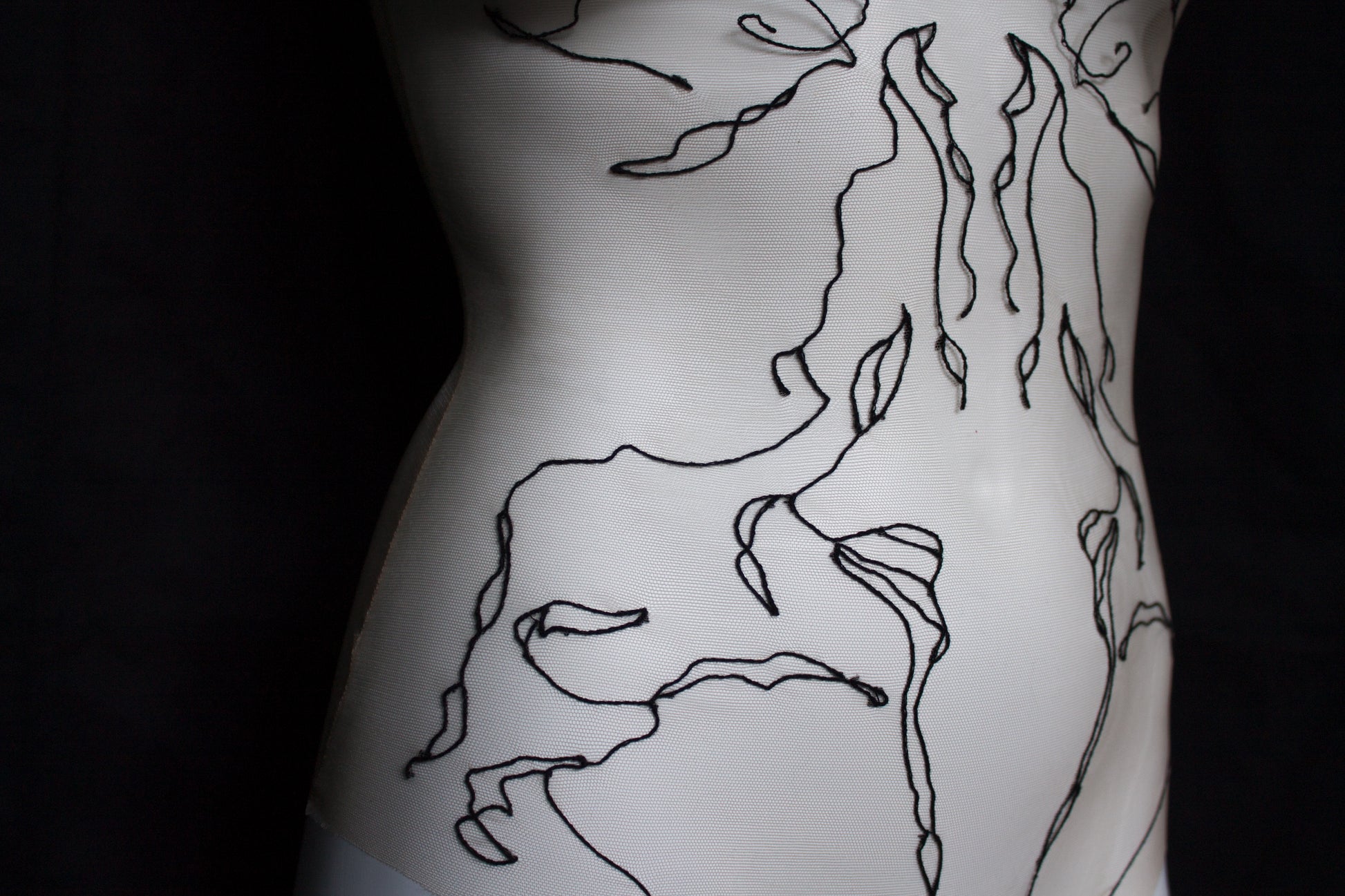 Black abstract designs on a mannequin with black background