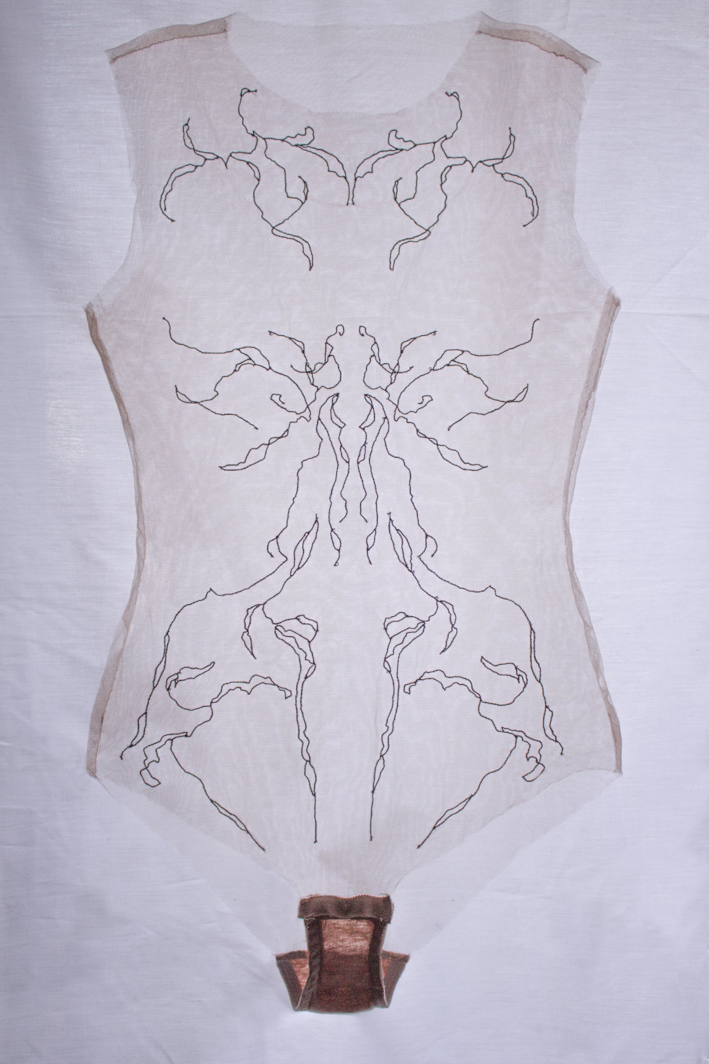 Sheer garments with intricate black patterns on a white background