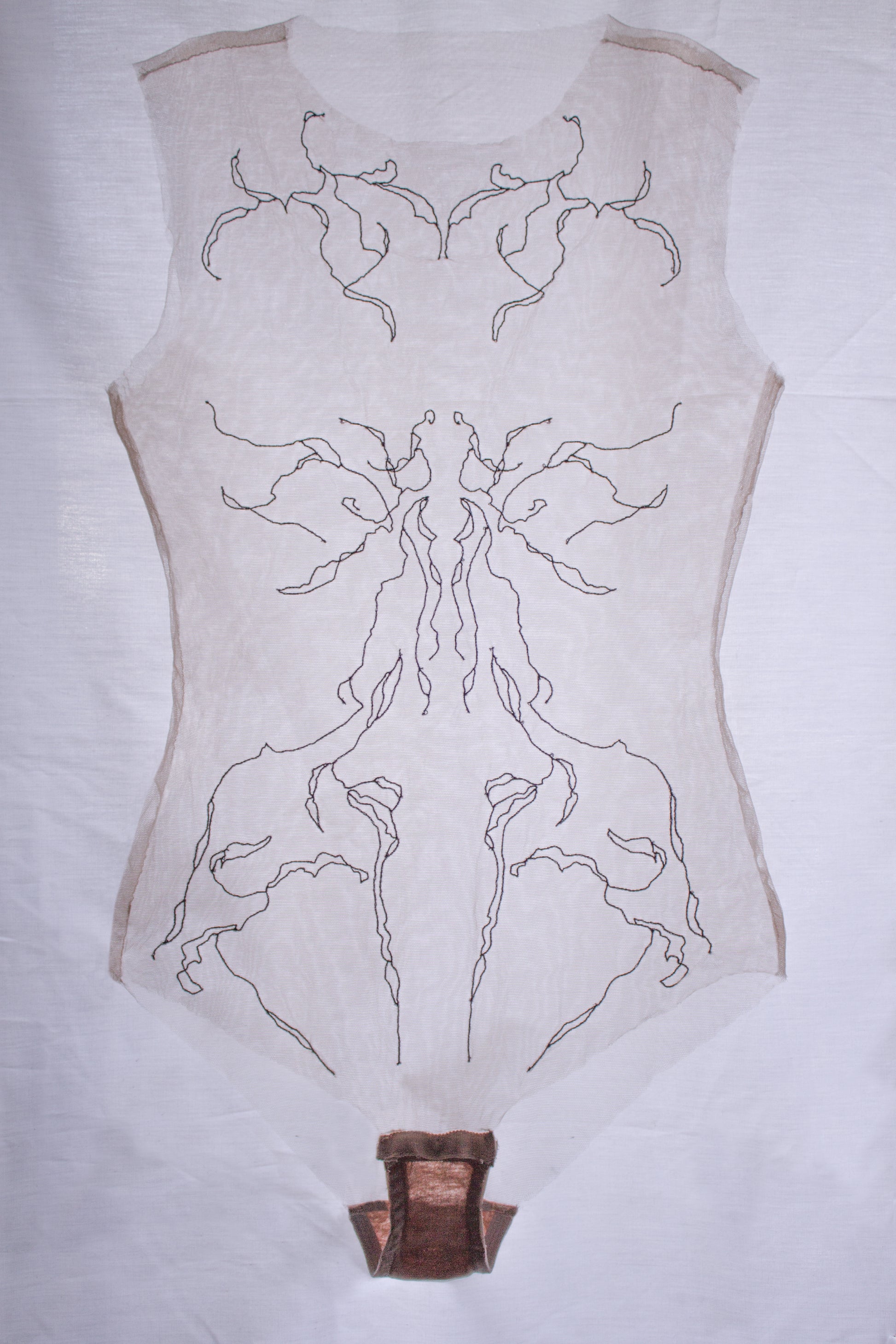 Sheer garments with intricate black patterns on a white background