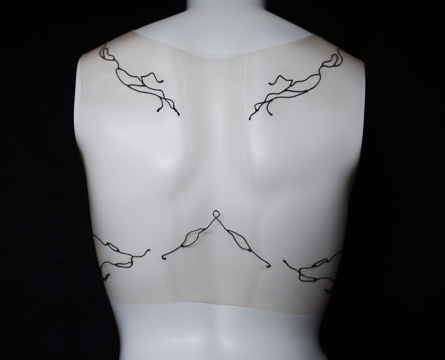 Mannequin with black wire body art on a black background