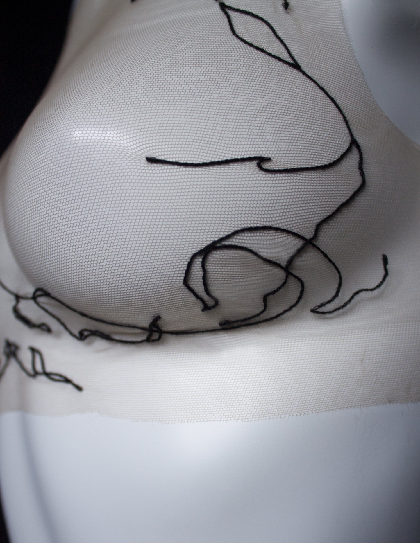 Close-up of a tattoo on a person's front with a black outline design.