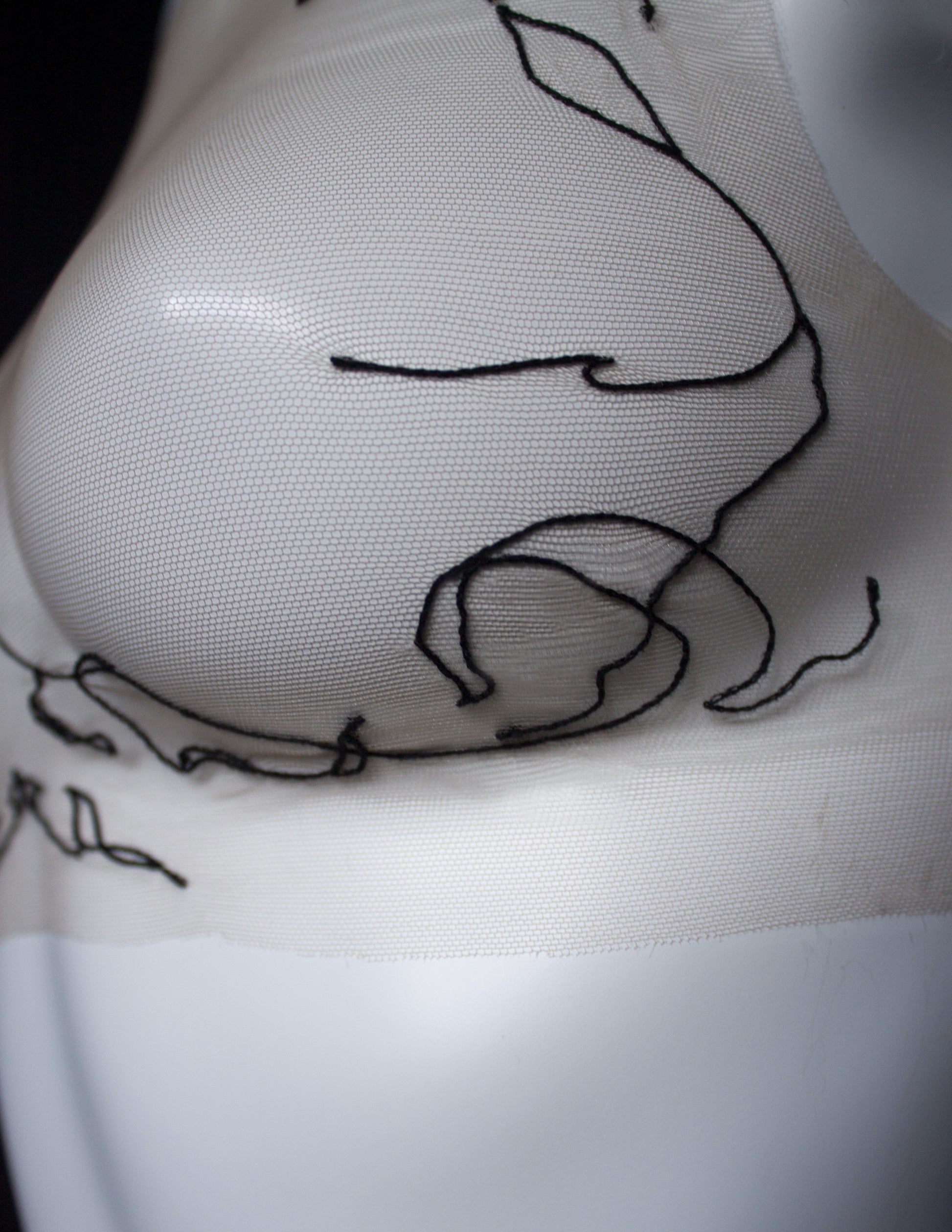 Close-up of a tattoo on a person's front with a black outline design.